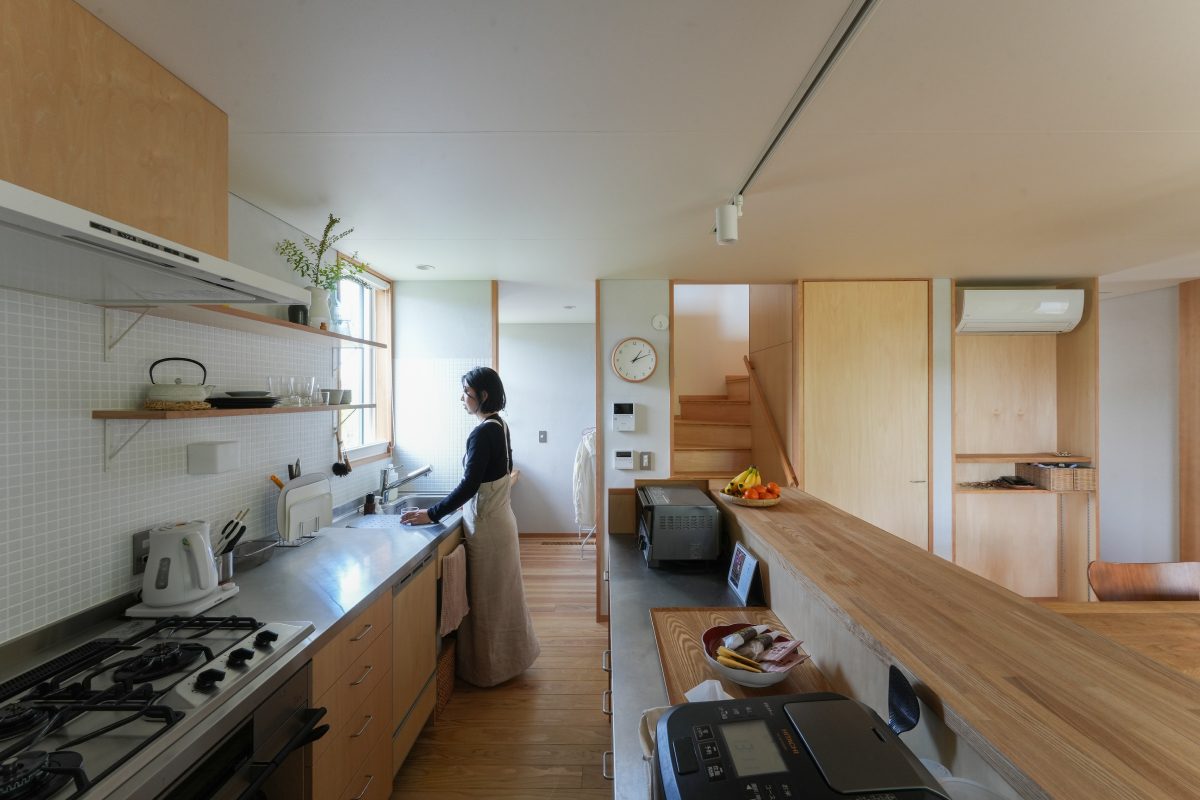 シンプルな白のタイルとオープン棚でナチュラルで心地よい佇まいのキッチン。窓の大きさ、吊戸棚の有無などは最後まで悩んだそう。