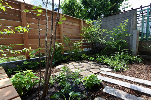 自然素材の家とウッドデッキとウッドフェンスと、石と植物と私